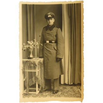 Photo of a German pionier soldier in full-length, in an overcoat and a visor cap. Espenlaub militaria
